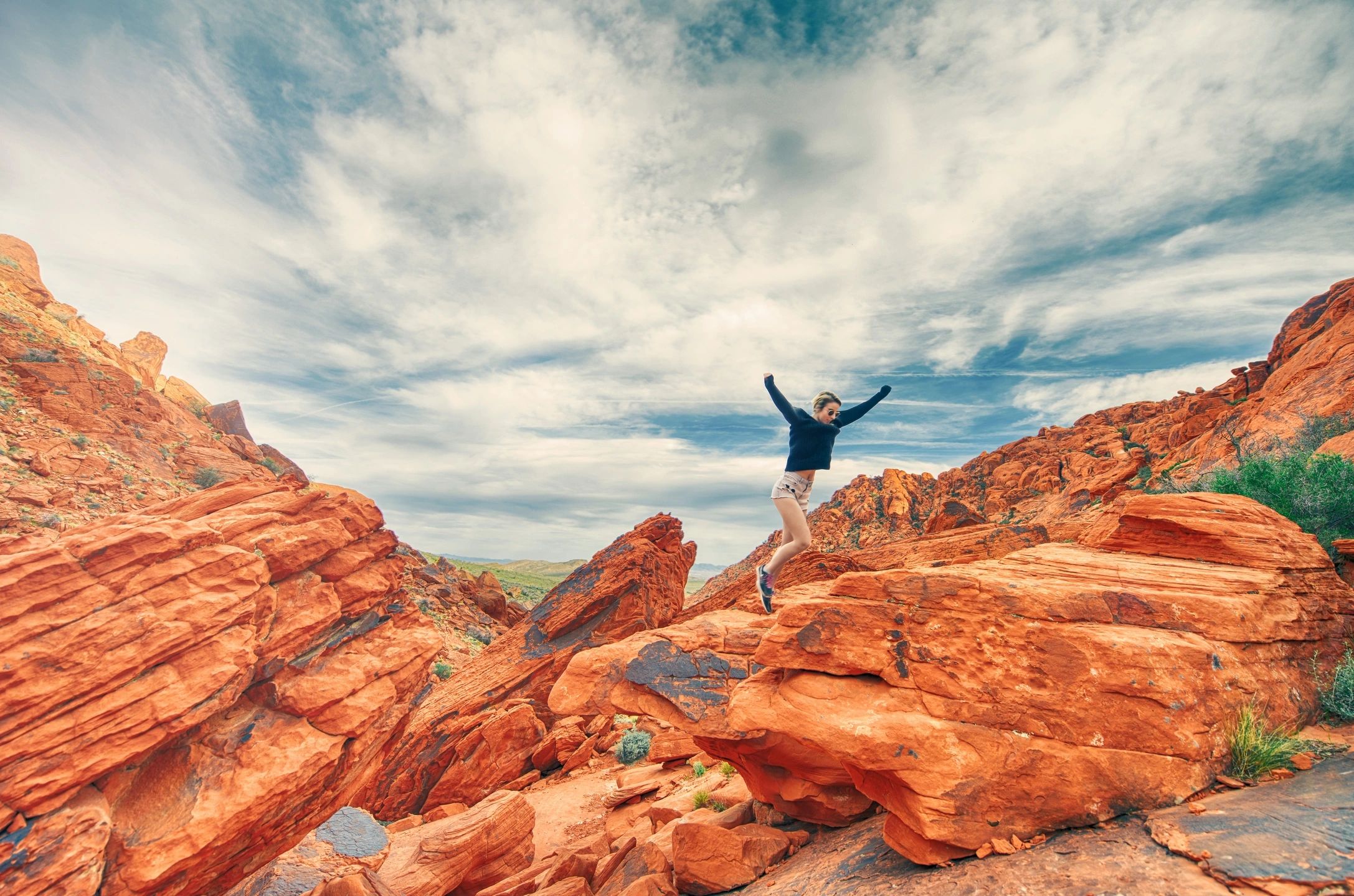 Person leaping over rocks, symbolizing overcoming limiting beliefs and embracing possibilities.